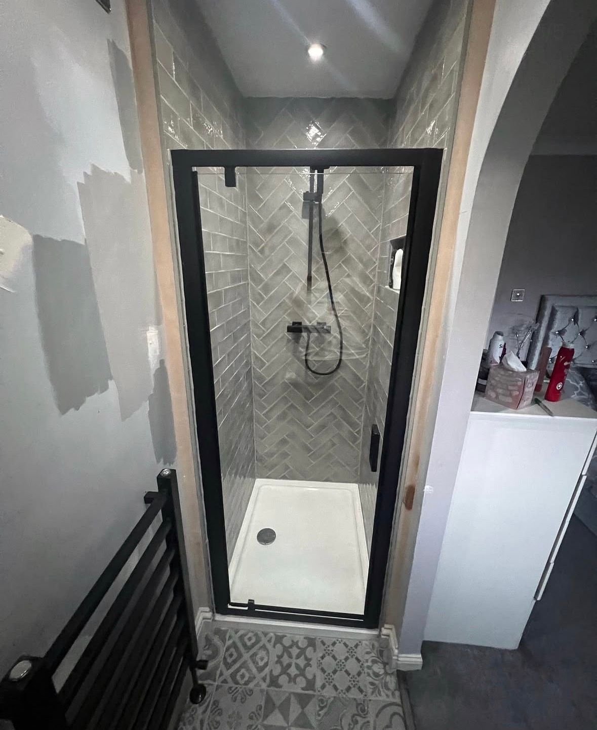 Black-framed shower enclosure with grey tiling