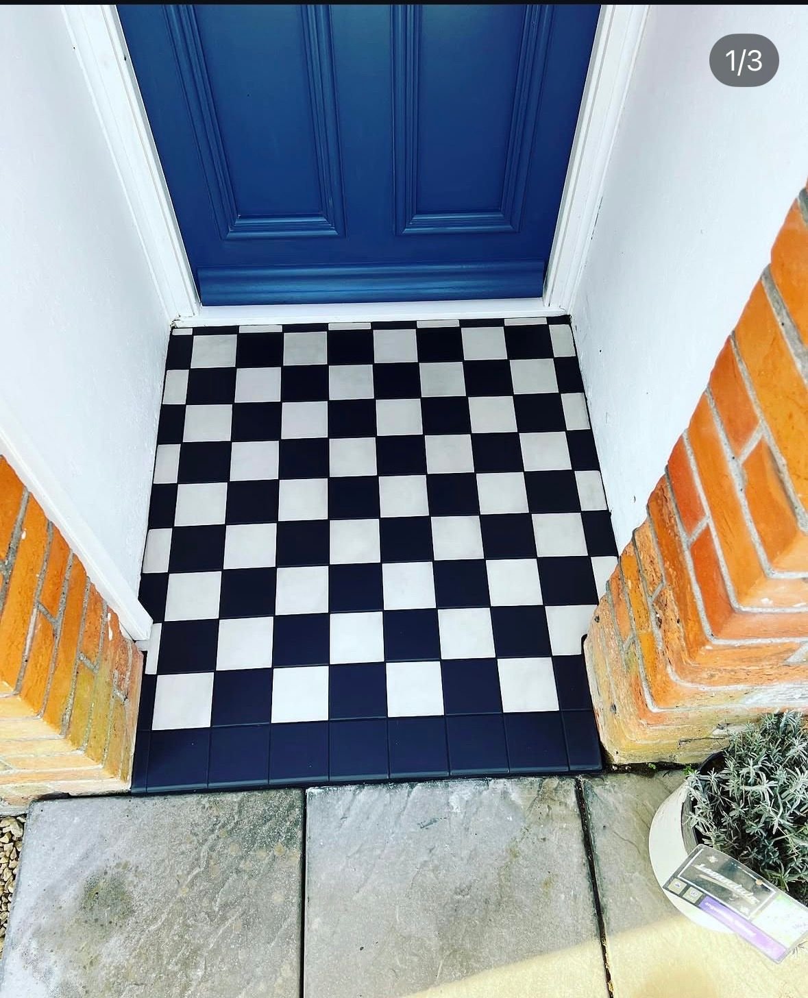 Checkerboard tiled porch floor with a navy door