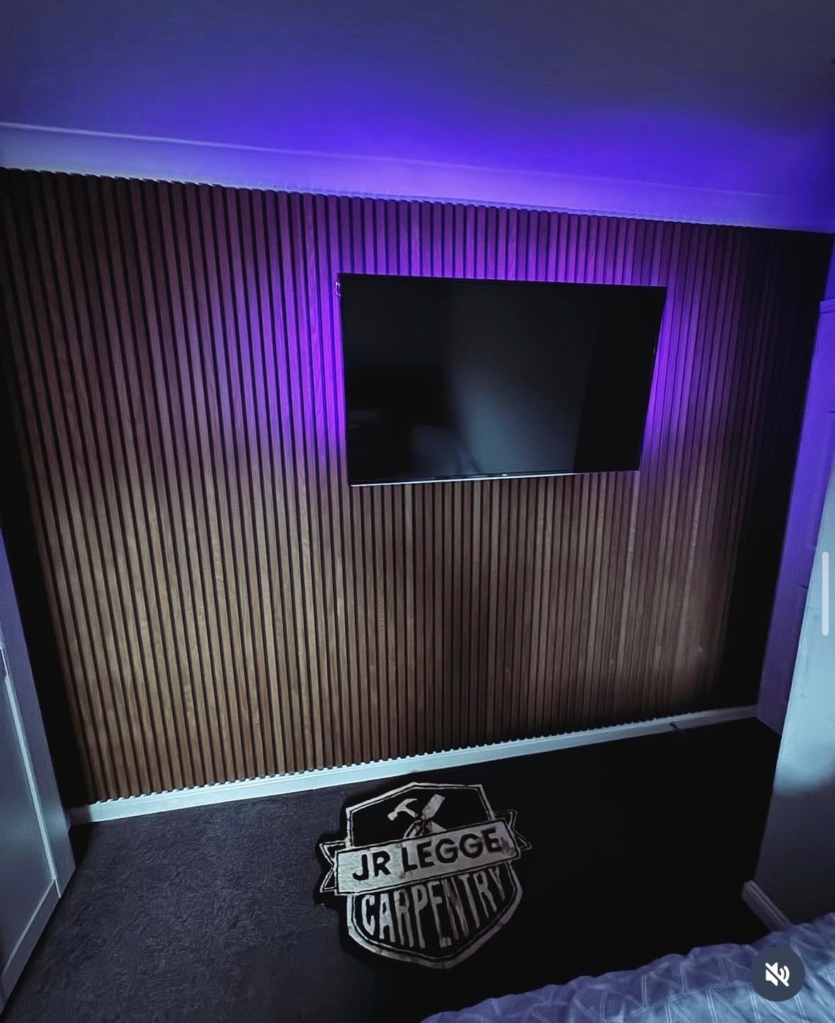 Dark slatted panelling media wall with TV